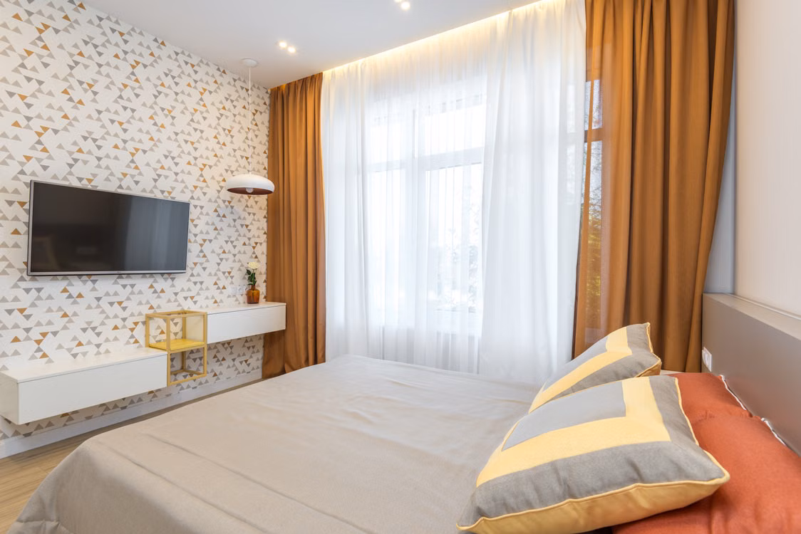 Hotel room with gold curtains layered over white sheers — stock photograph